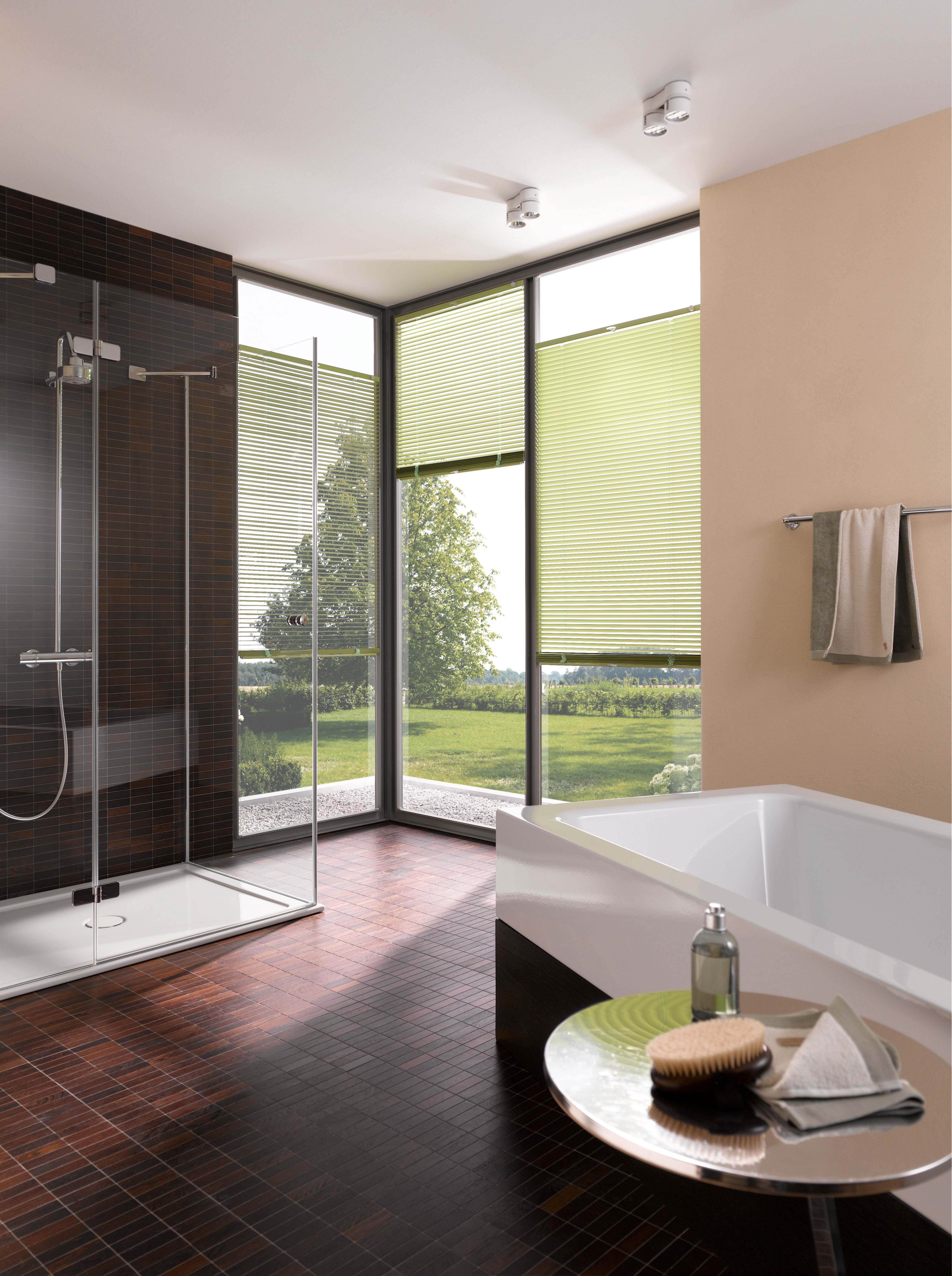 Grüne Jalousien im Bad an Eckfenstern, flexibler Blendschutz mit Blick in den Garten.