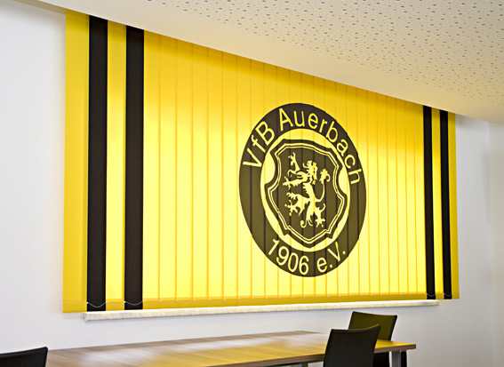 Vertikalanlage mit individuellem Druck – gelb-schwarzer Lamellenvorhang mit Vereinslogo.