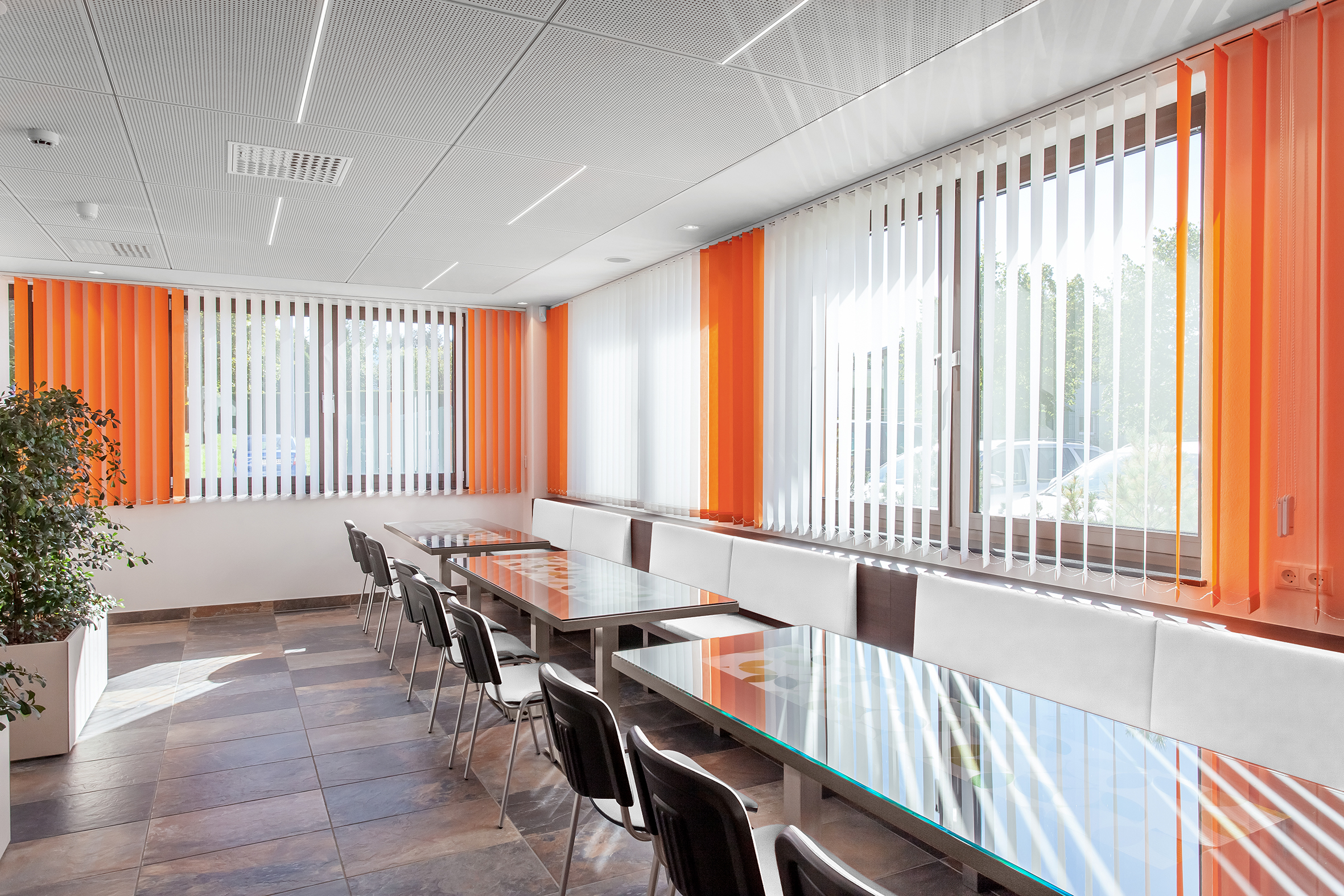 Weiß, orangener Lamellenvorhang in Kantine an Fenster angebracht. - Schmidt Insektenschutzrahmen GmbH