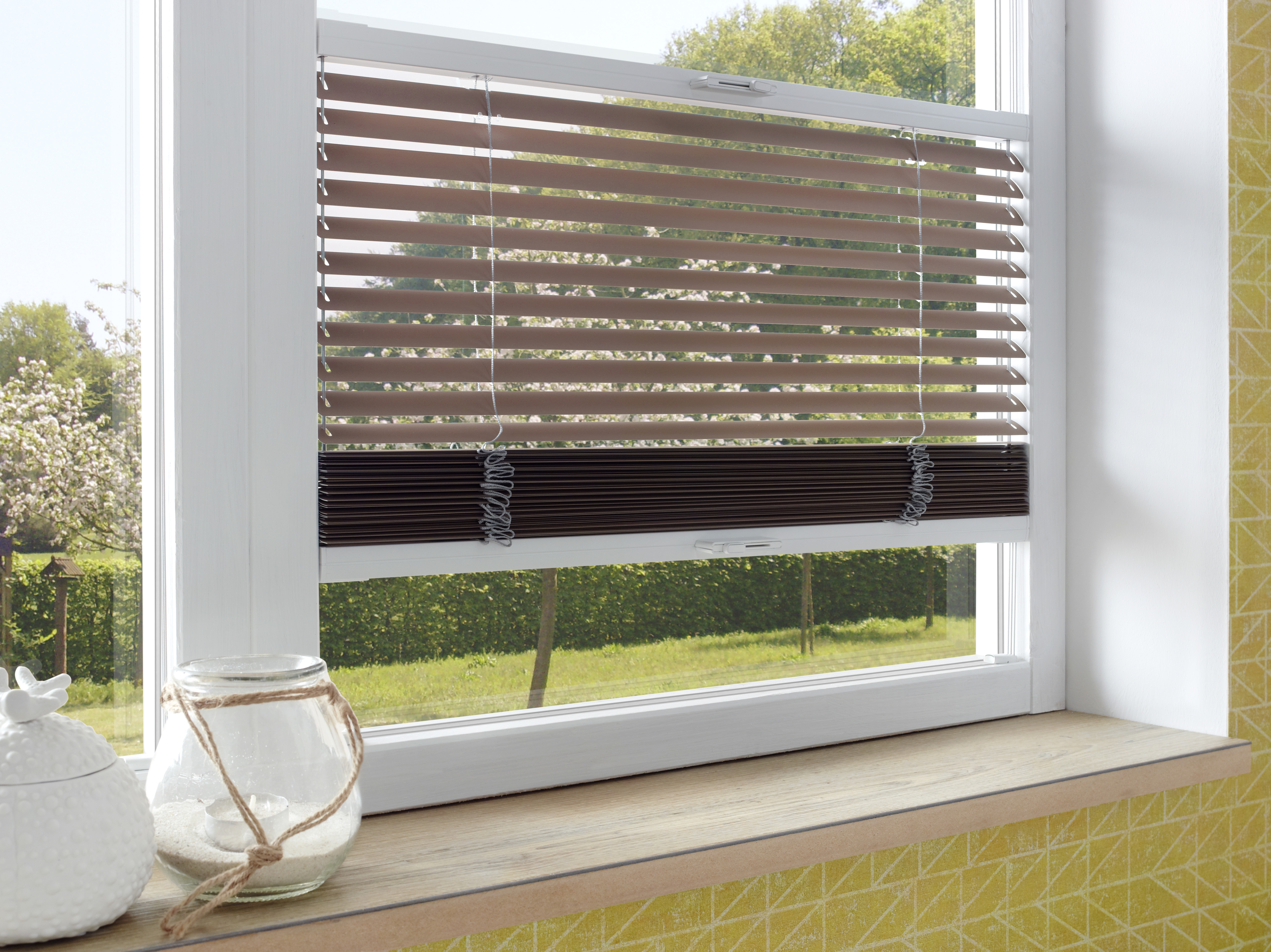 Braune Jalousie am Fenster mit Gartenblick, stufenlos regulierbarer Lichteinfall.