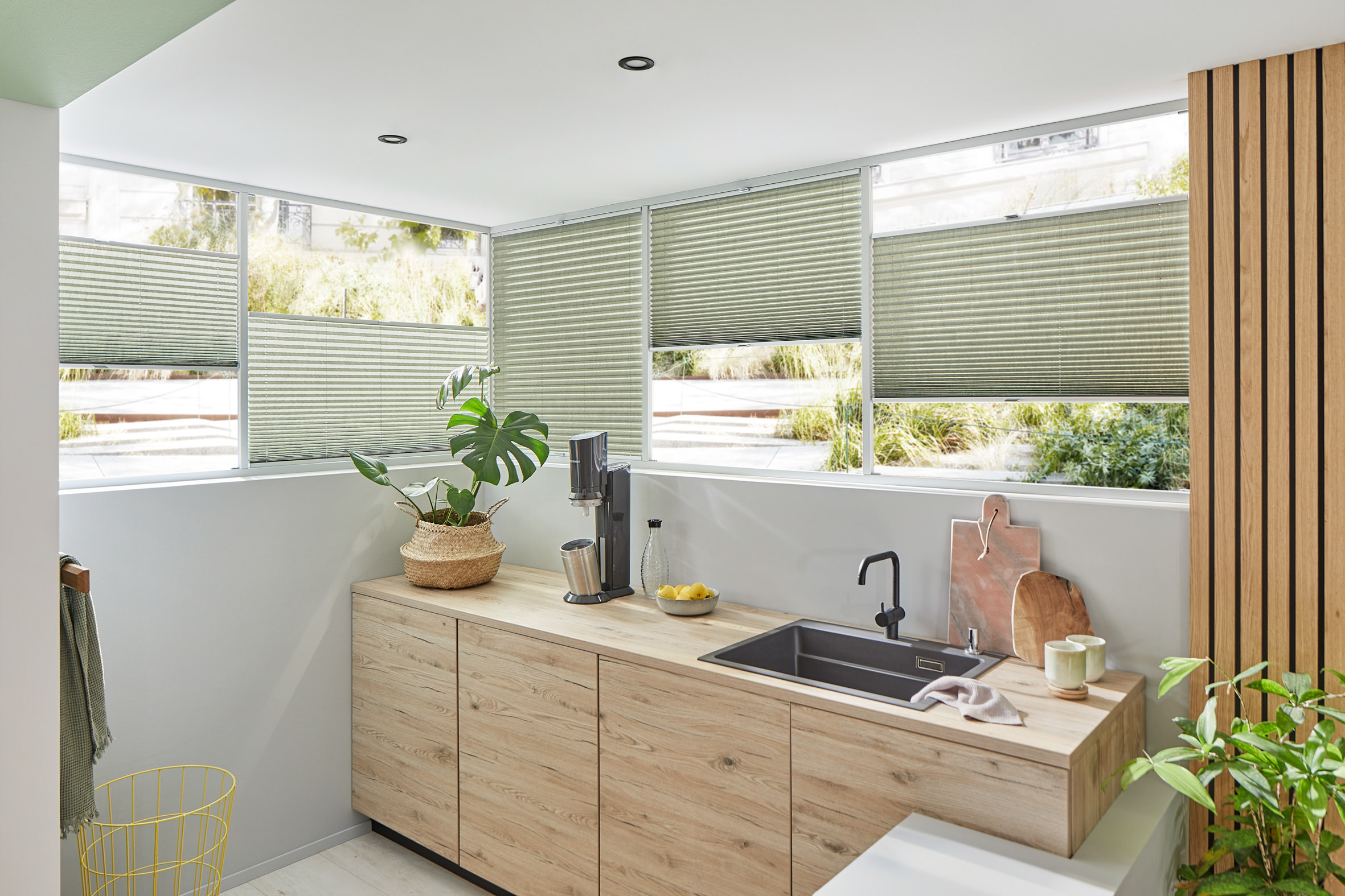 Grüne Plissees in moderner Küche – natürliche Lichtstimmung und Sichtschutz.