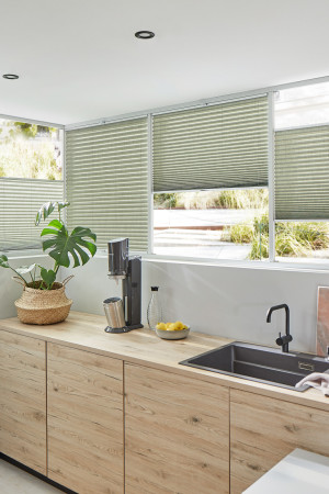 Grüne Plissees in moderner Küche – natürliche Lichtstimmung und Sichtschutz.